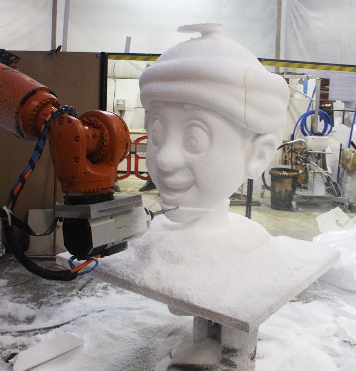 A CNC robot cutting a cartoon head out of polystyrene