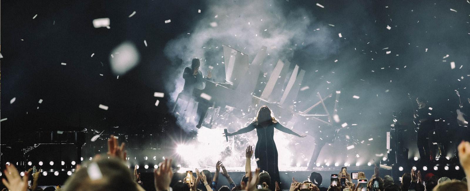 Adele and Eric Wortham on stage at her Las Vegas residency, with confetti falling down as the audience claps.