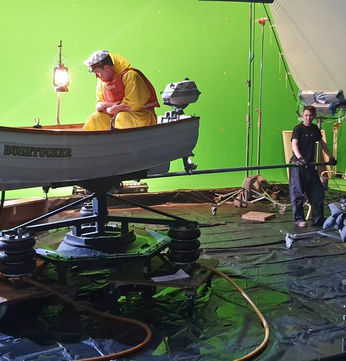 A technician operating a rig of a rocking boat on set