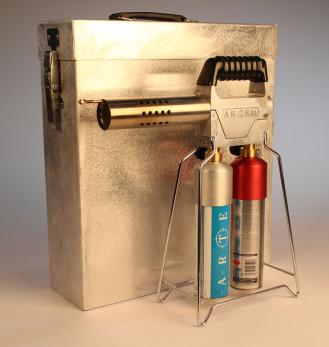The Artem smoke machine placed in front of its metal case, on a white background