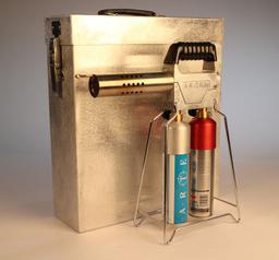 The Artem smoke machine placed in front of its metal case, on a white background